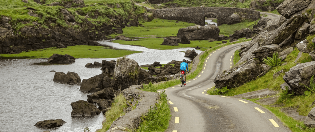 Cyclist on mountain pass flanked by river