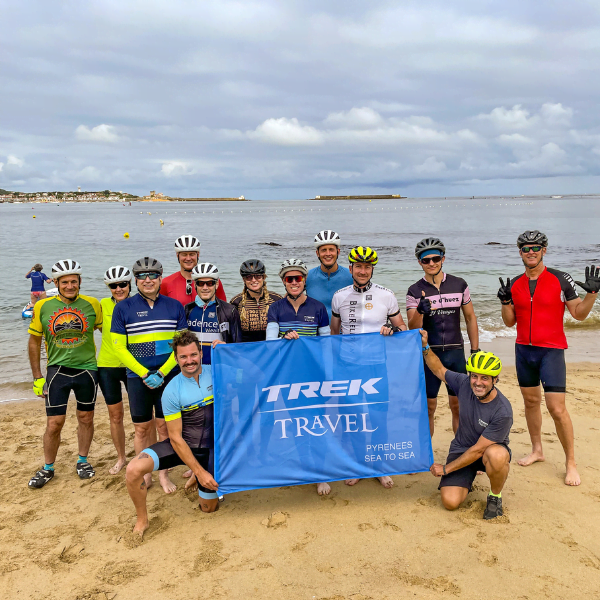 people posing with their bike helmets on holding a flag